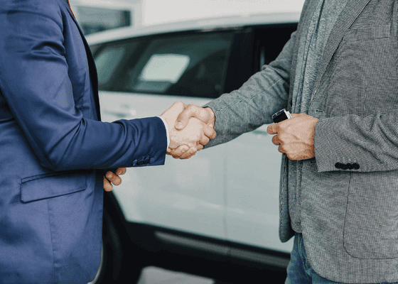 Auto loan handshake by a vehicle — auto note portfolios on Debexpert